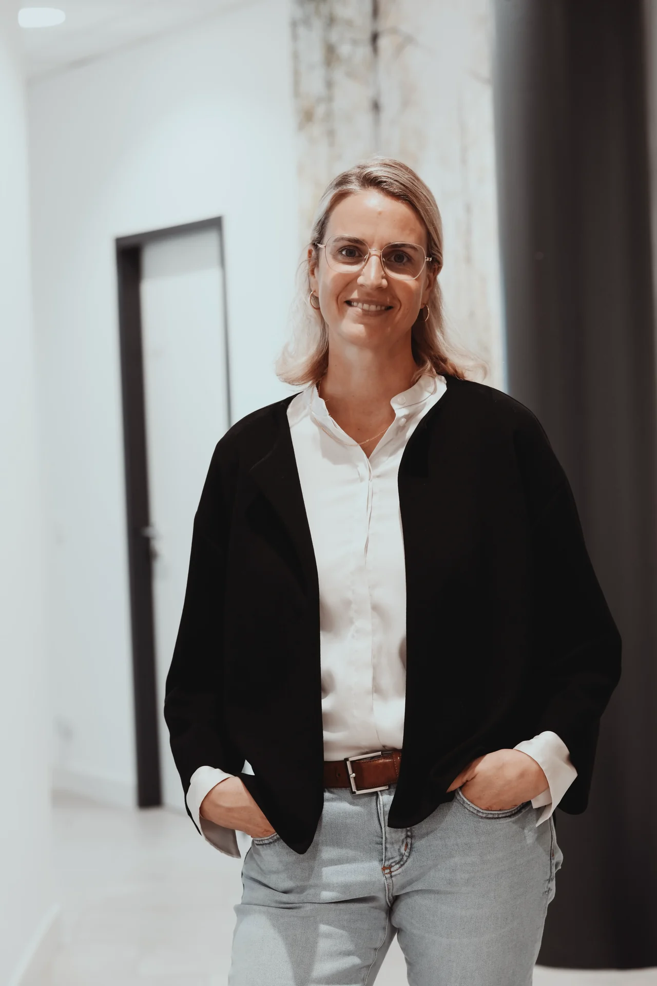Carolin Binder lächelt mit Brille im Flur von Focus Medical in Aalen.